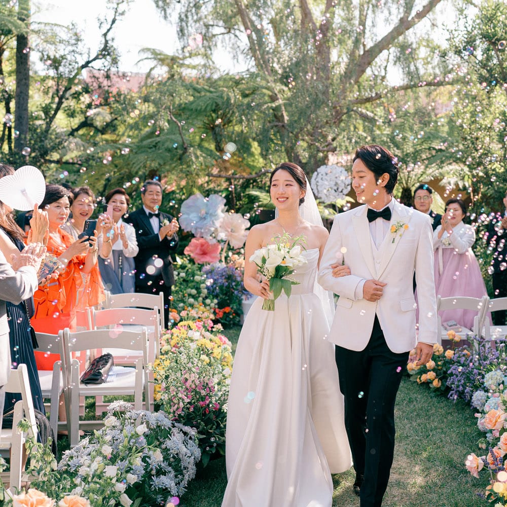 Bright flowers at the couple's outdoor ceremony set a stunning contrast to the darker, classical hues at the reception.