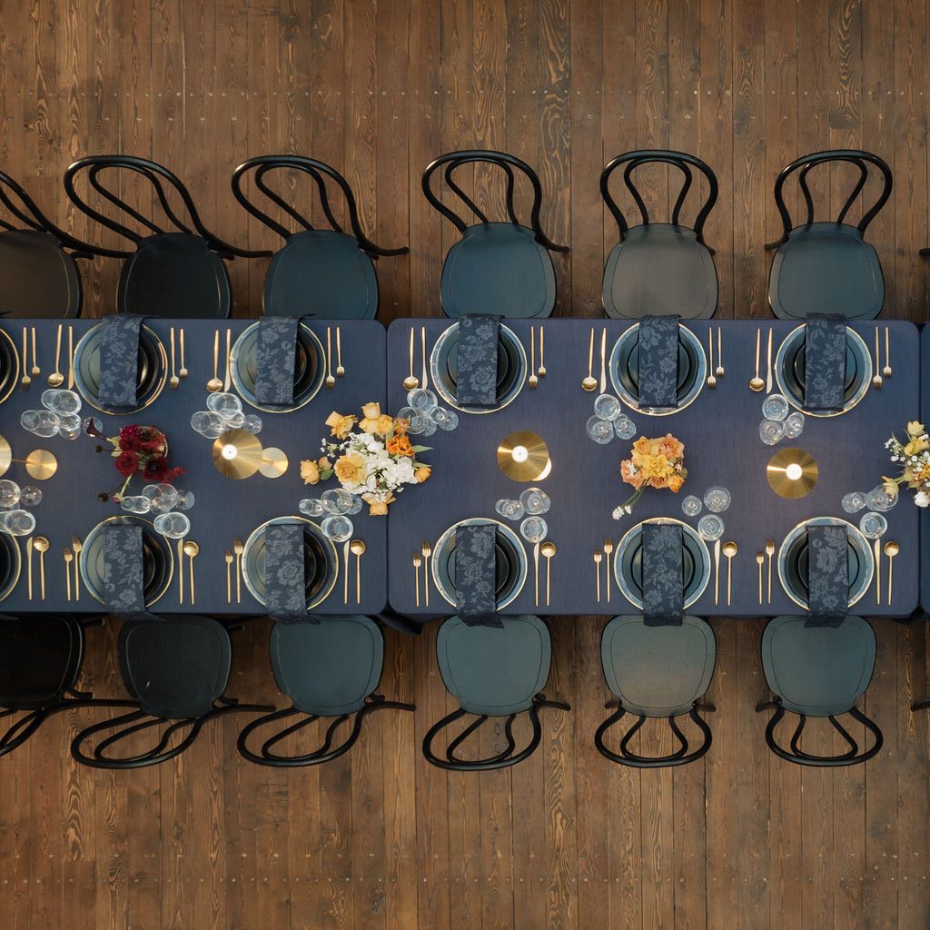 Bold tablescape featuring dark navy tones and metallic accents in one long table at Ellsworth Block