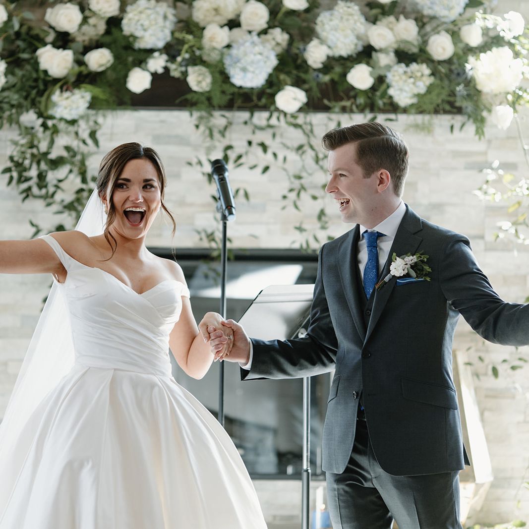 Bride and groom smile as they walk back down the aisle at the Skyroom