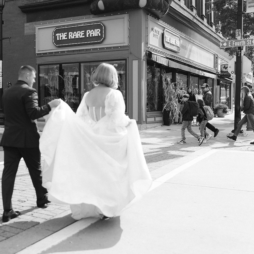 Josh Holds Caitlin's Dress as they Cross the Street in Northfield