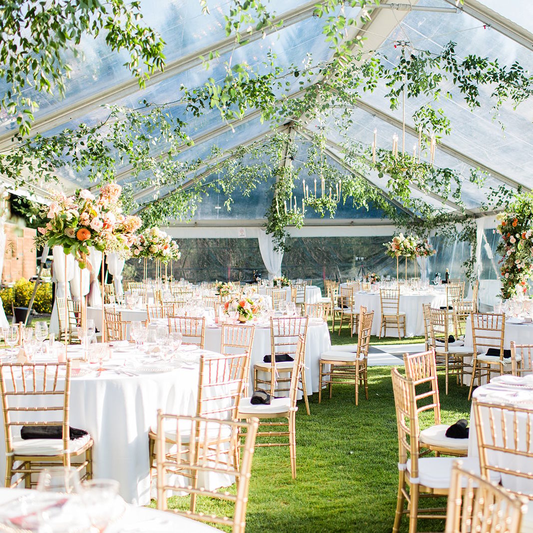 Tented reception space featuring greenery and lush florals at Tumble Creek