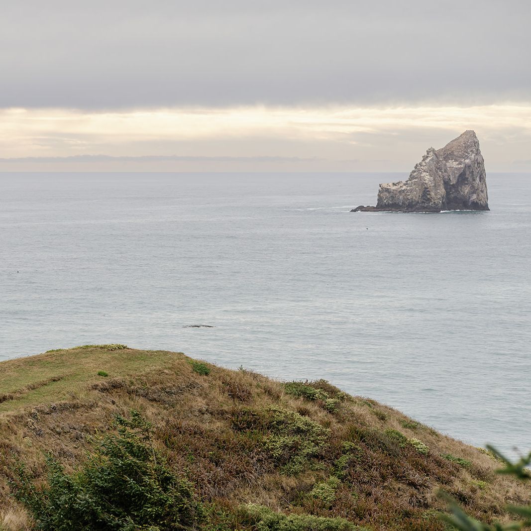 Model walks along the cliffs of Crook Point with the great expanse of water in the backdrop