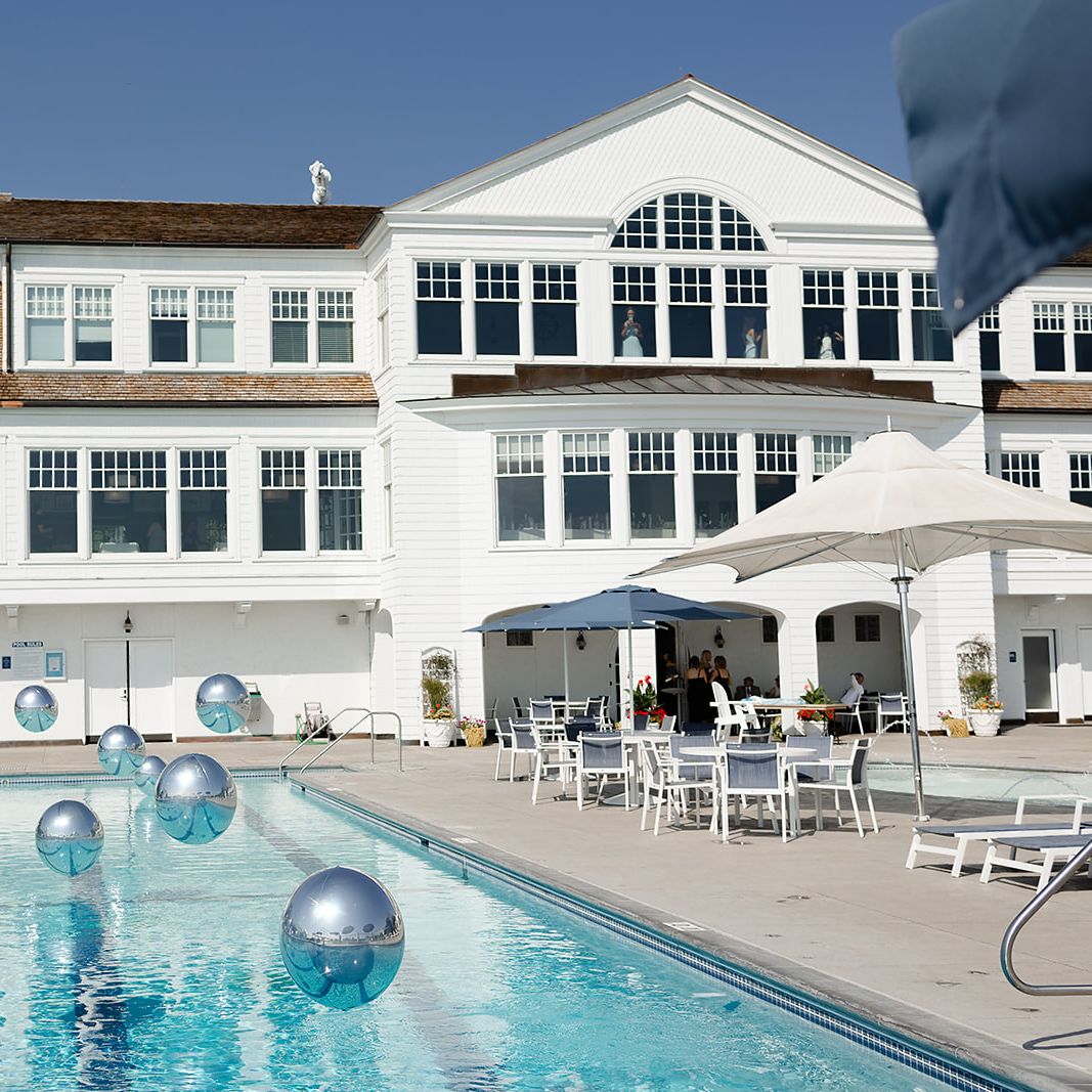 Sunny shot of reception at White Bear Yacht Club featuring pool and floating balloons