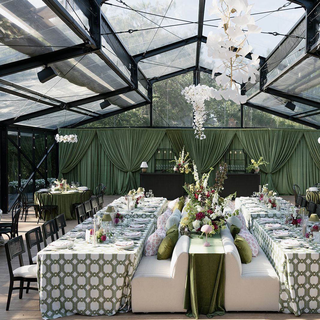 Bold maximalist reception design featuring luxe green draping and textured chandeliers at Woodland Glasshaus