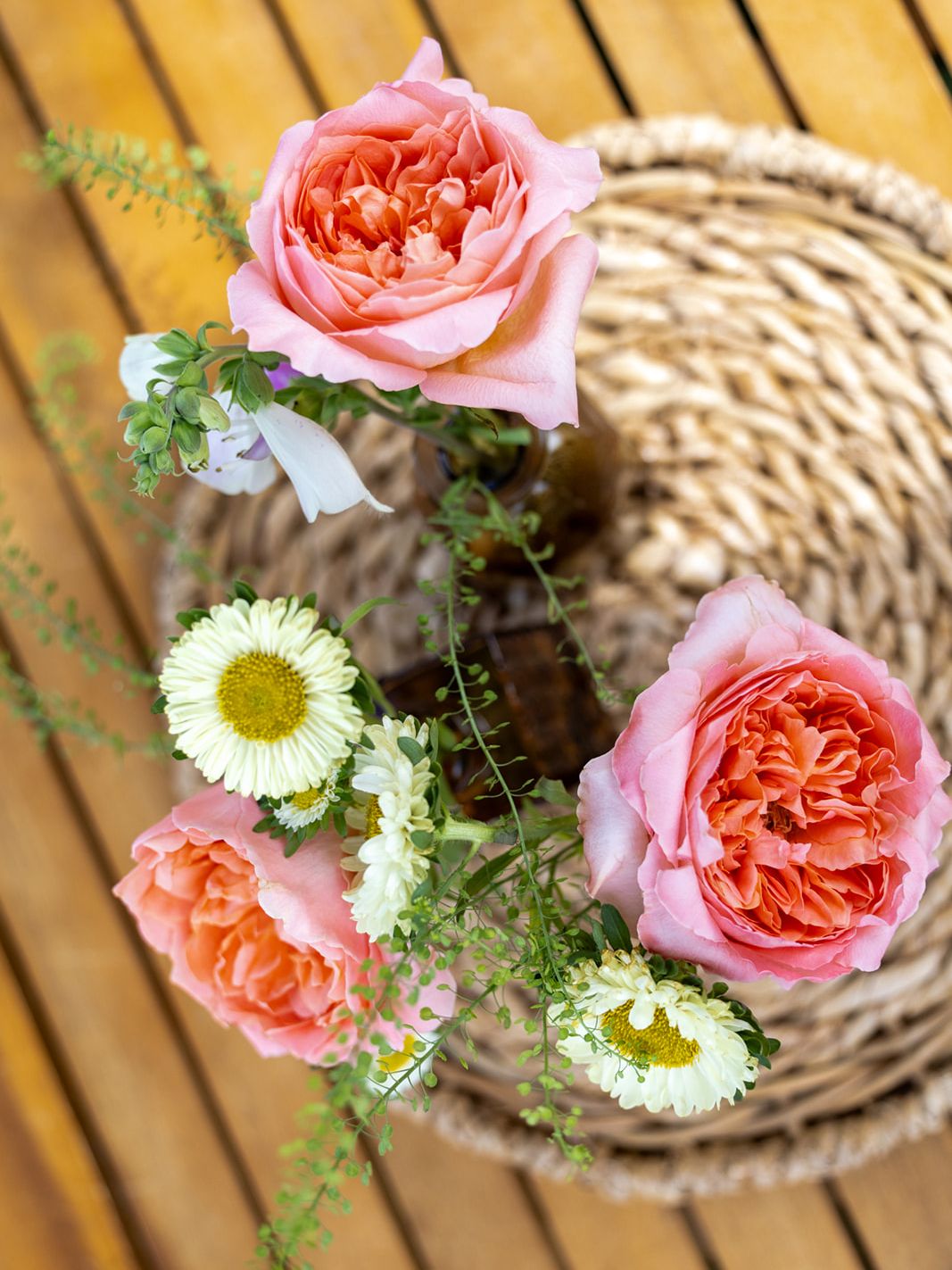 Pink and white floral arrangements decorate a wooden table at the ILEA Napa-Sonoma event