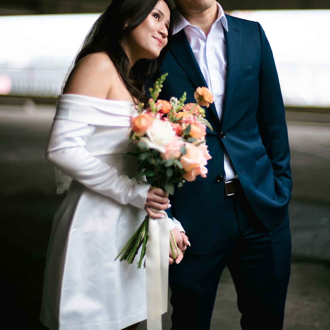 Bride Holding Bouquet and Resting Head on Husband's Shoulder