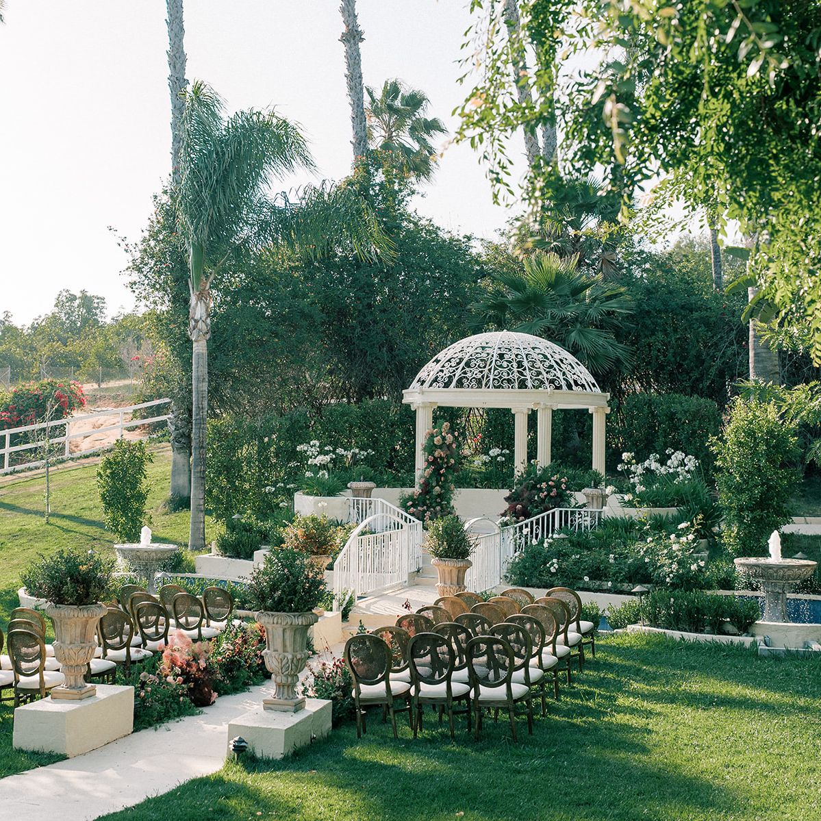 Sun-soaked outdoor imagined ceremony featuring deep moody floral palette and crisp white pergola at the center on the grounds of Villa Zosaneli