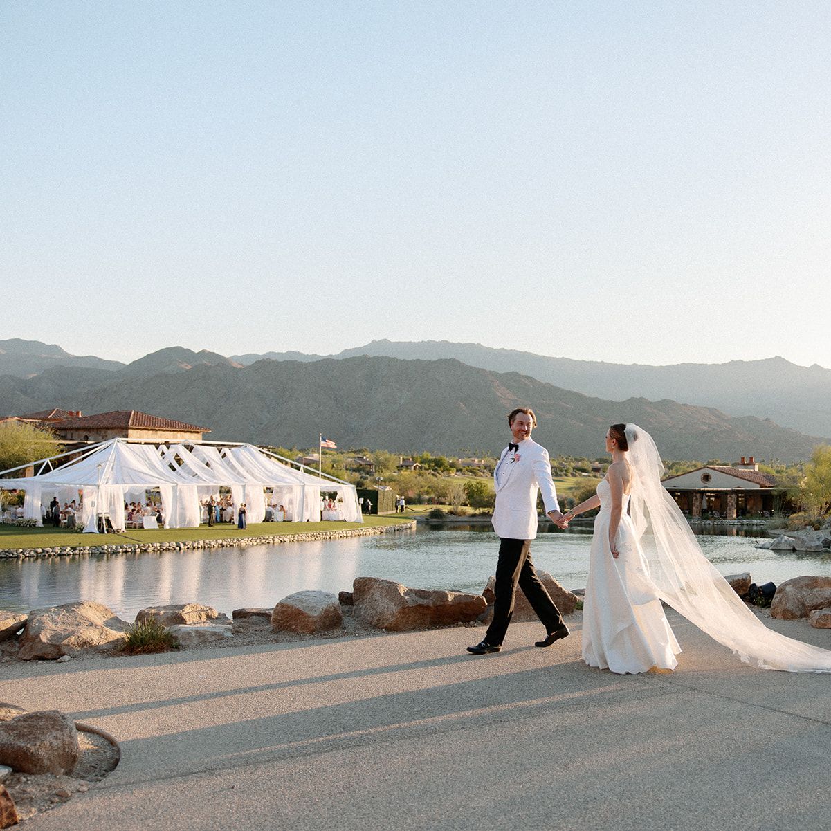 Emily and Vladimir cross the grounds of The Reserve Club during golden hour on their wedding day