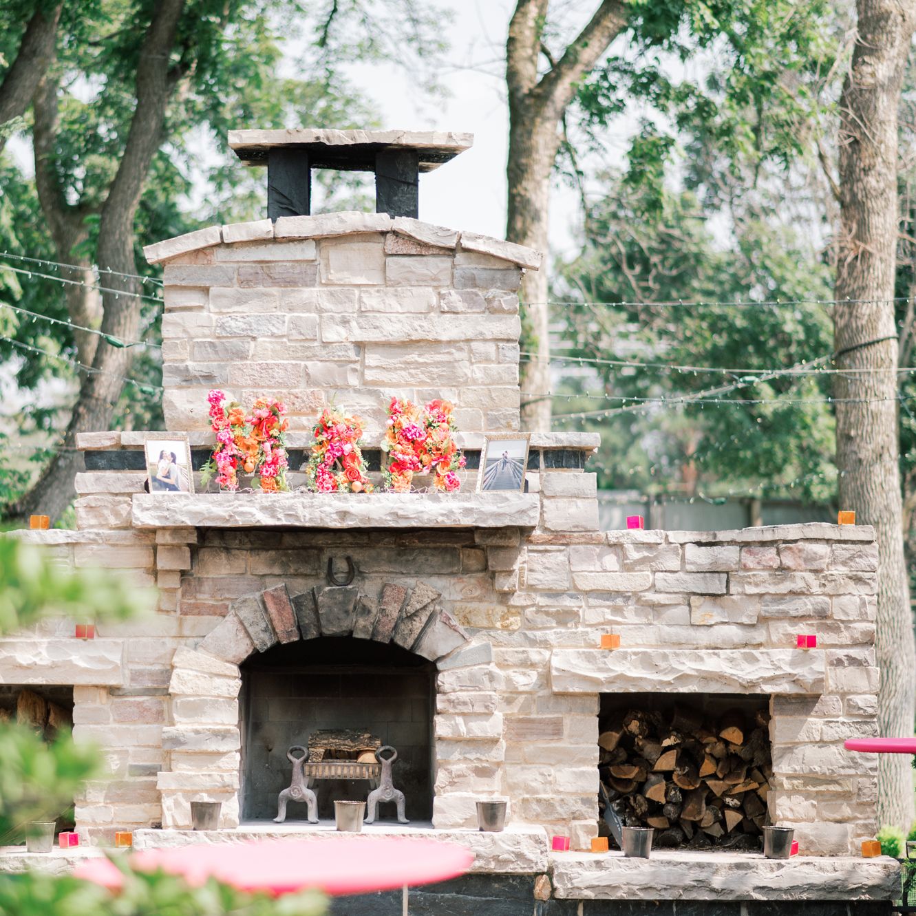 "M + M" Spelled out with floral arrangements atop an outdoor fireplace at The Gardens of Castle Rock
