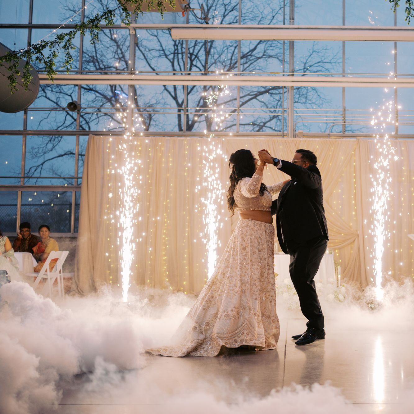 Bride and groom share their first dance accompanied by fog and cold sparks 