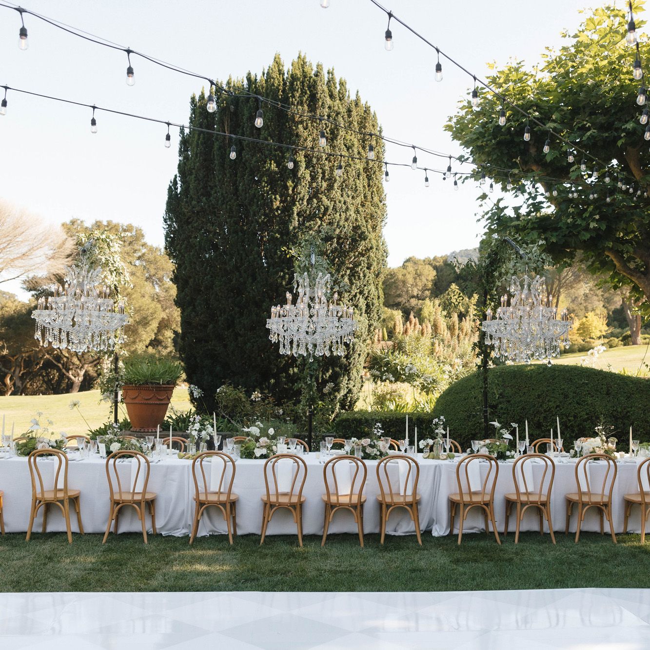 Ariel and Kiefer's lush al fresco reception featuring hanging chandeliers on the grounds of Stonepine Estate