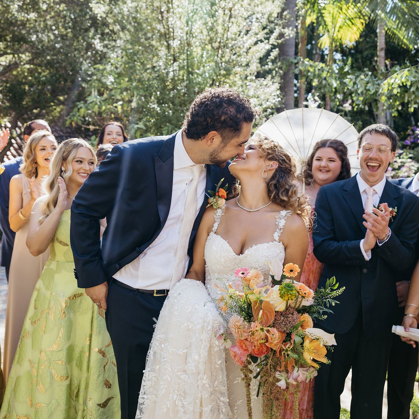 Rachel and Stefano share a kiss with their wedding party around them at private residence in San Juan Capistrano wedding day