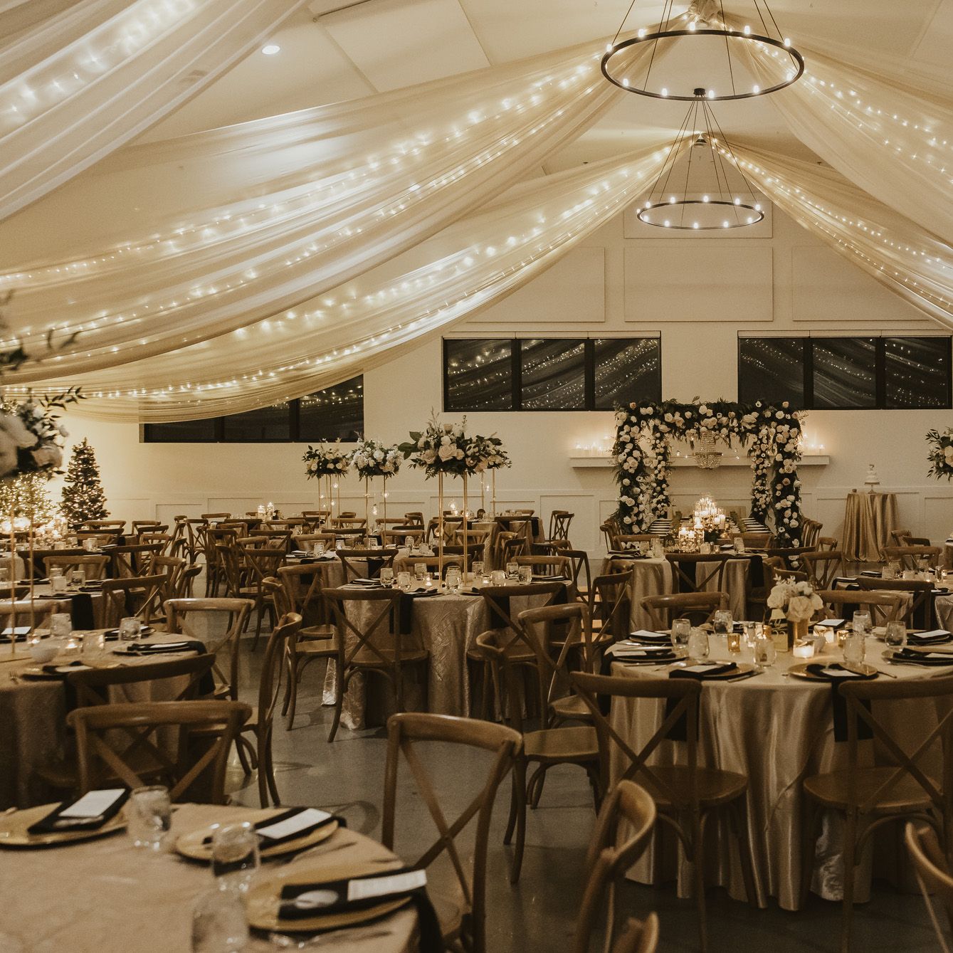 Classic and elegant reception design featuring draping and ivory florals in winter wedding at Woodhaven
