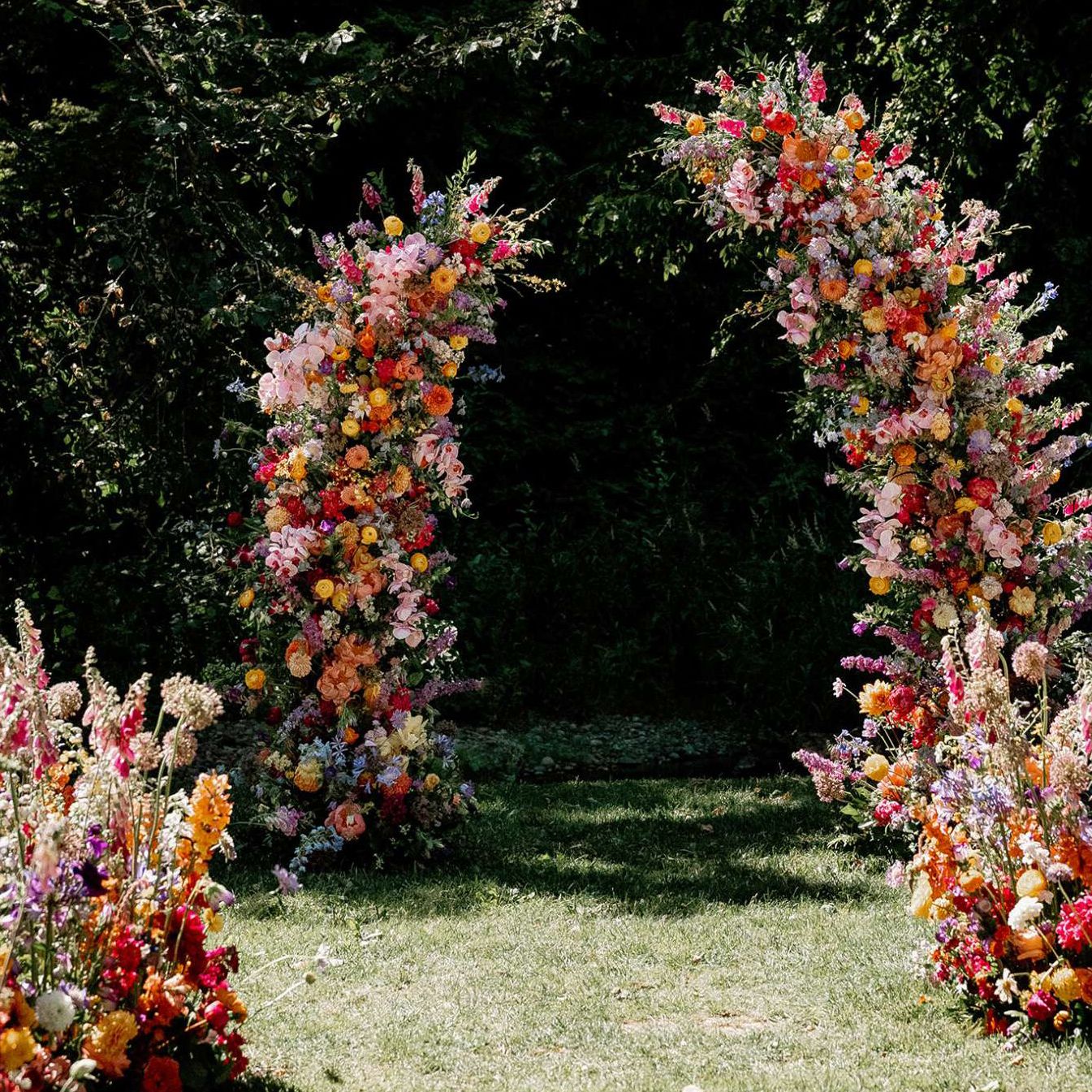Bold abundance of blooms line the outdoor aisle in wedding day at Fox Hollow Farms