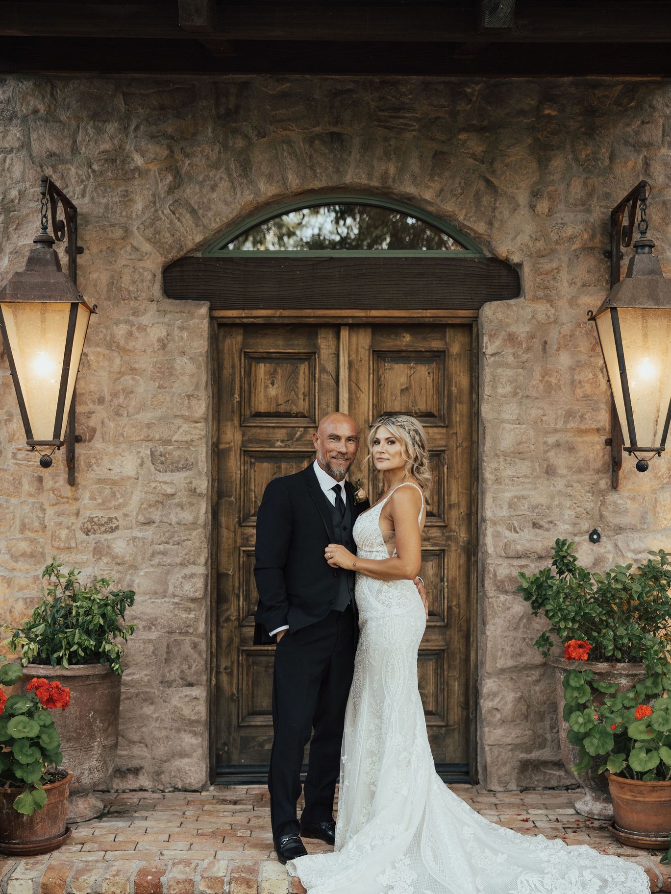 Groom and bride pose together on their wedding day after the groom’s JD Barba grooming experience