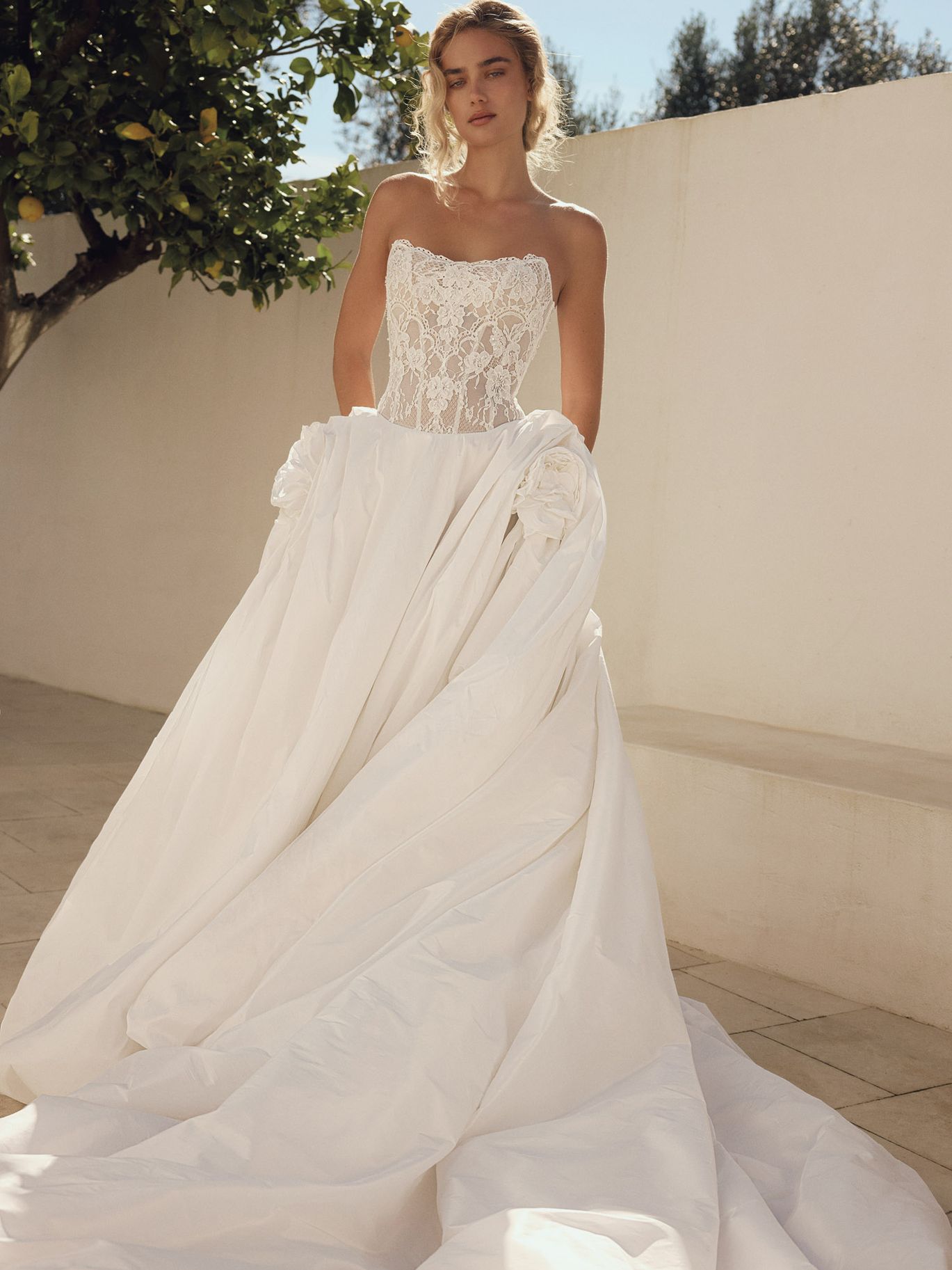 Eva Lendel Encanto wedding dress with a strapless lace corset and voluminous draped overskirt, featured in a romantic draping trend roundup from New York Bridal Fashion Week.