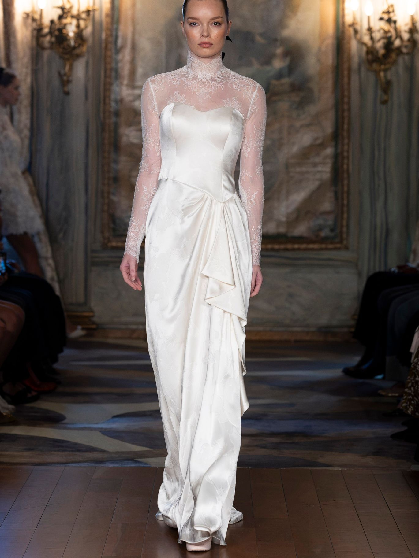 Sareh Nouri Tuxedo Rose Bolero from the Fall 2027 bridal collection, a high-neck Chantilly lace topper with long sleeves styled over a draped wedding gown.