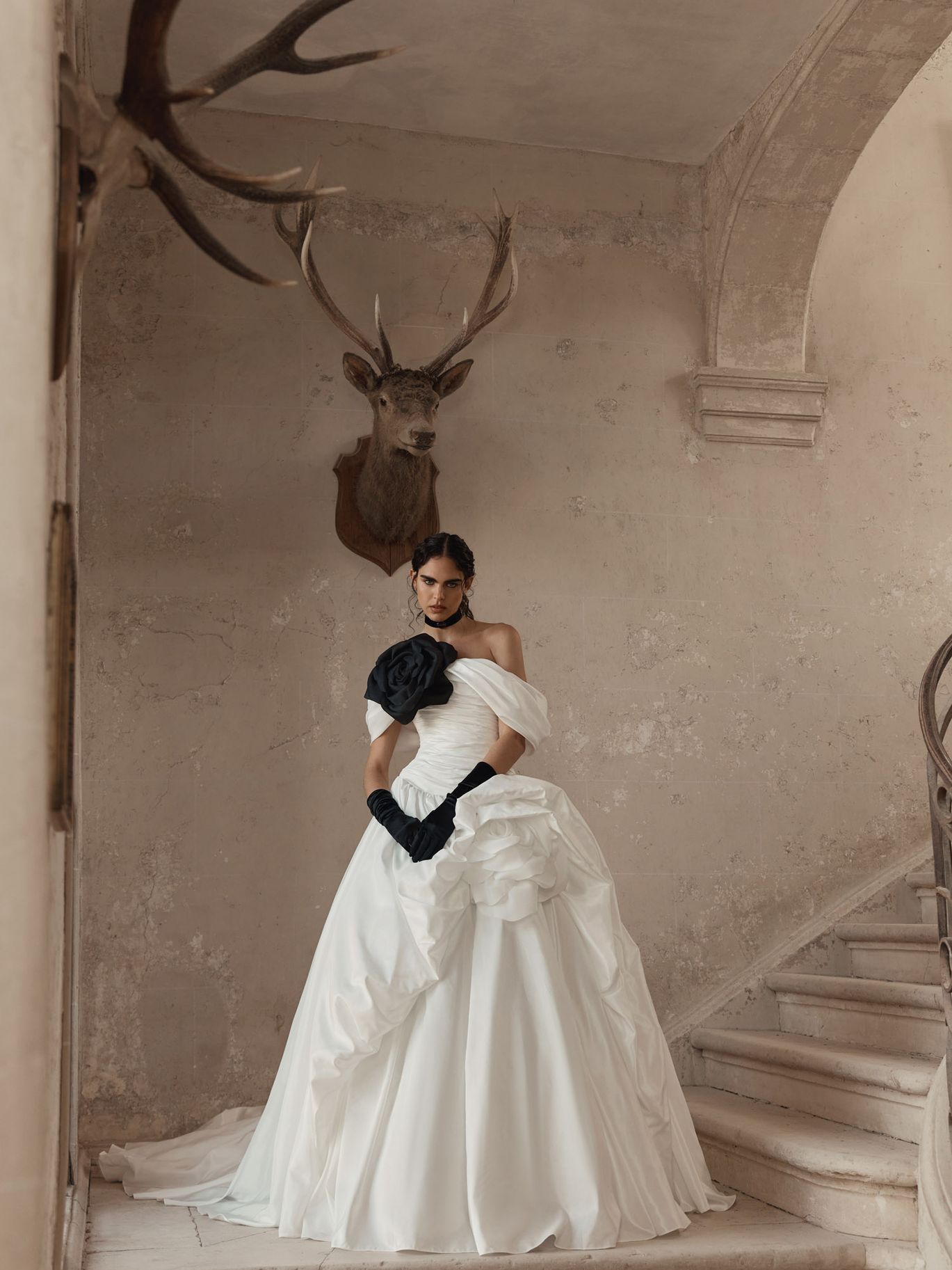 WONA Atelier Arcane wedding dress with a strapless bodice, sculpted draping and a dramatic black floral accent, featured in a New York Bridal Fashion Week trend roundup.