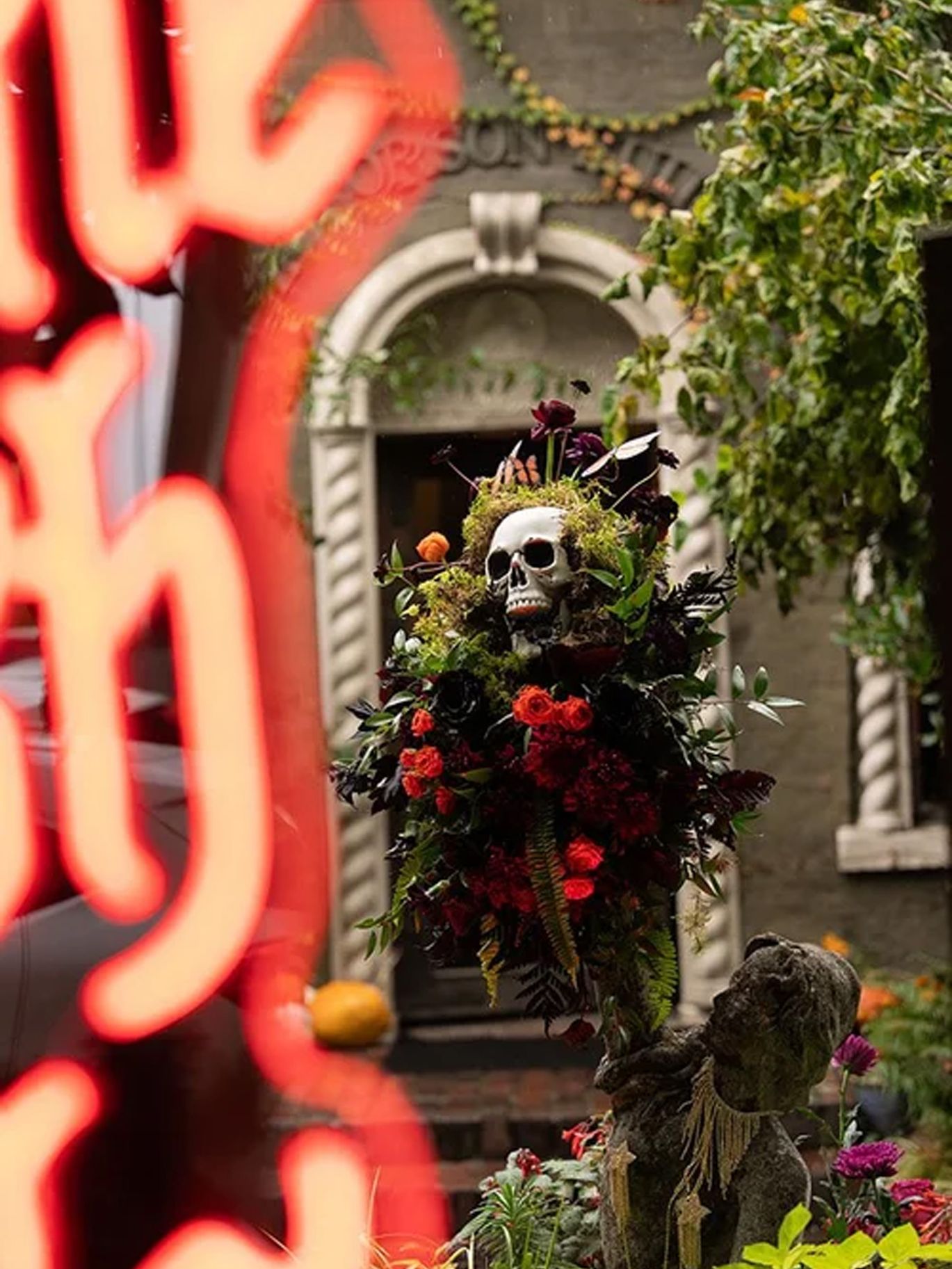 A skull surrounded by flowers and greenery tops a Halloween wedding centerpiece at The Corson Building.