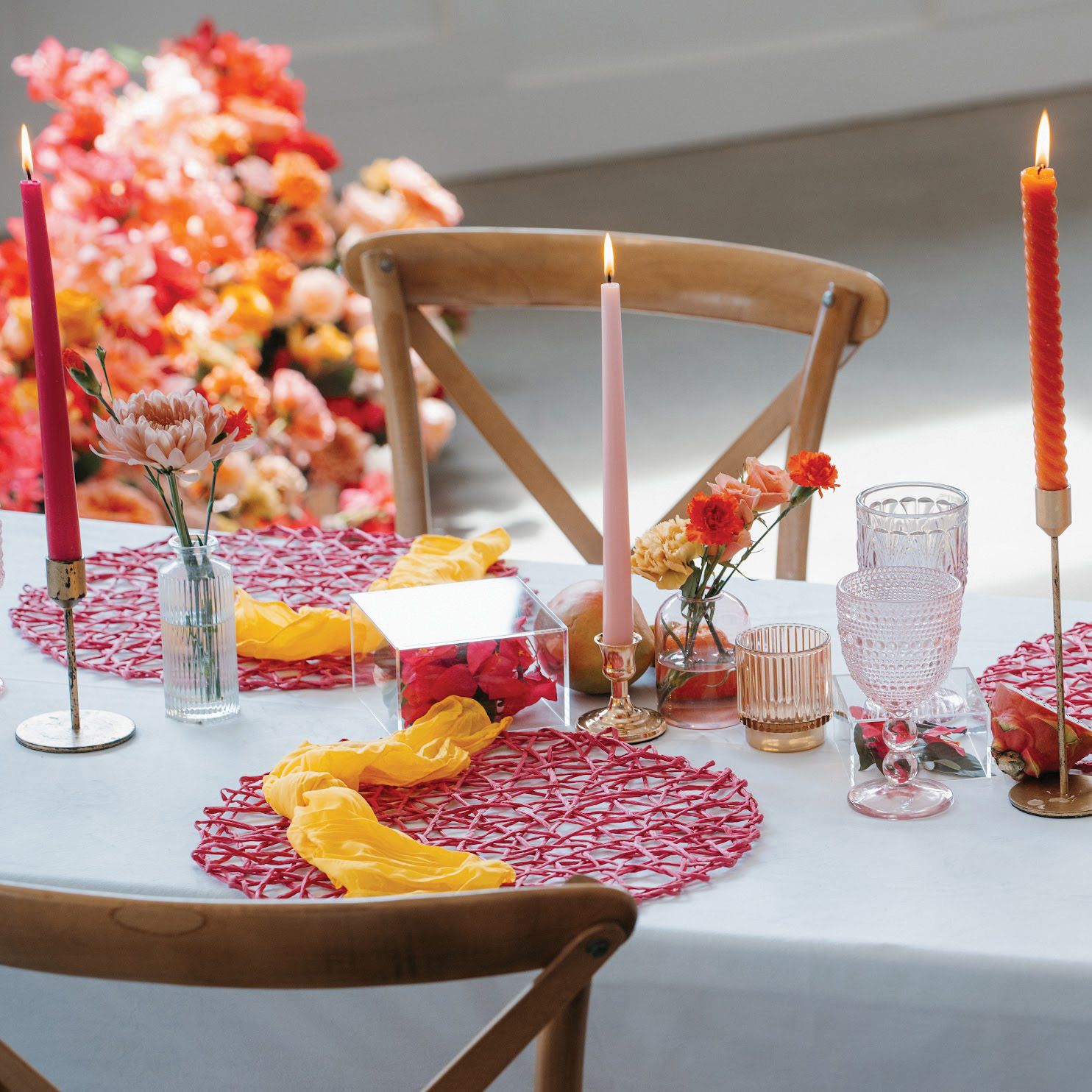 Vibrant tablescape featuring juicy hued florals, fruit accents and taper candles at Woodhaven