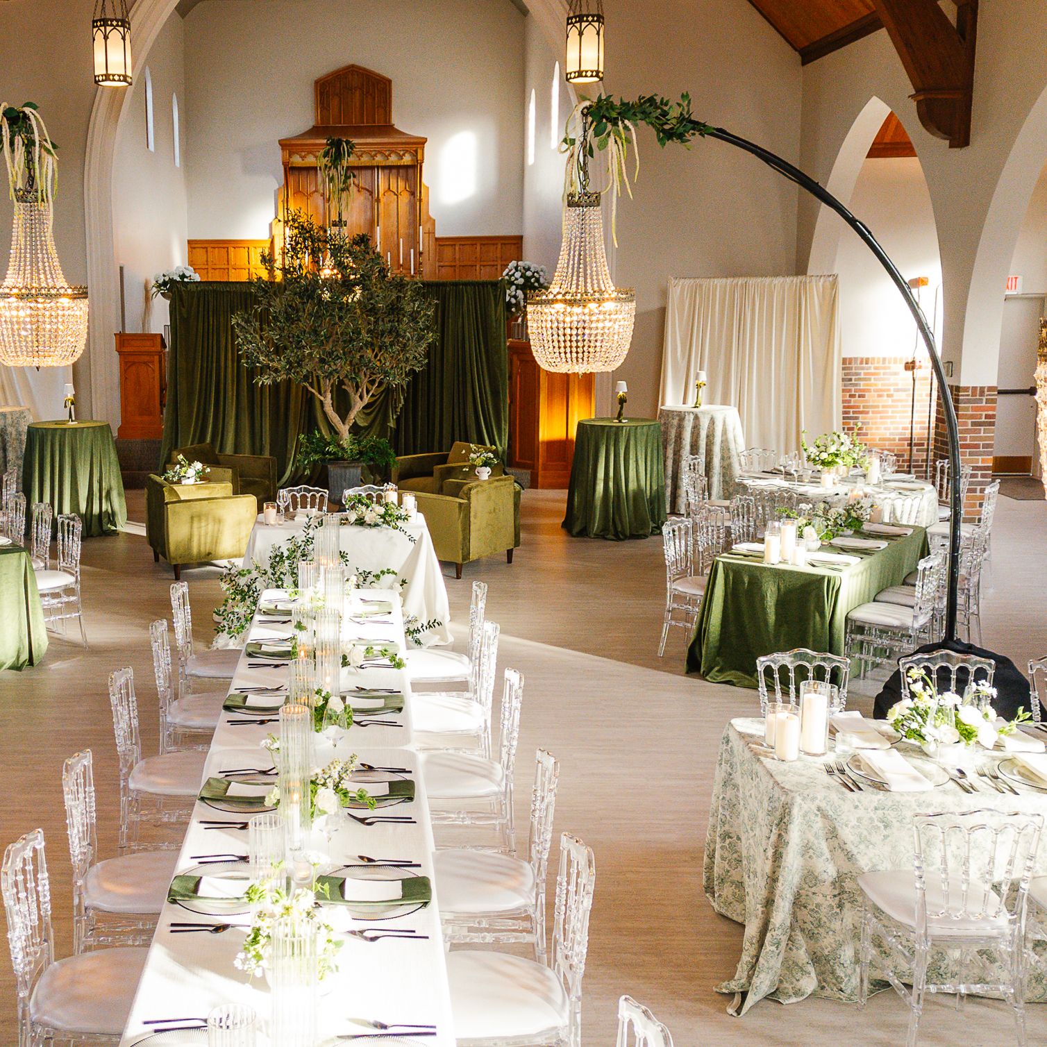 Reception scene inside Westlin Hall featuring classic design in ivory and green hues, dramatic draping and sparkling chandeliers