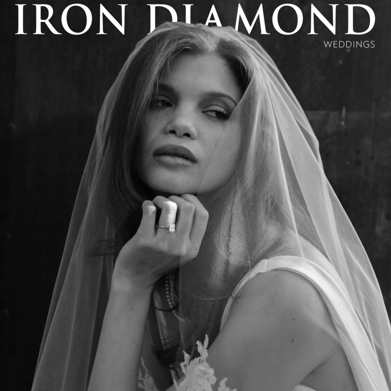 Black-and-white IRON DIAMOND Weddings magazine cover featuring a close-up bridal portrait of a woman wearing a sheer veil and diamond engagement ring, resting her chin on her hand.