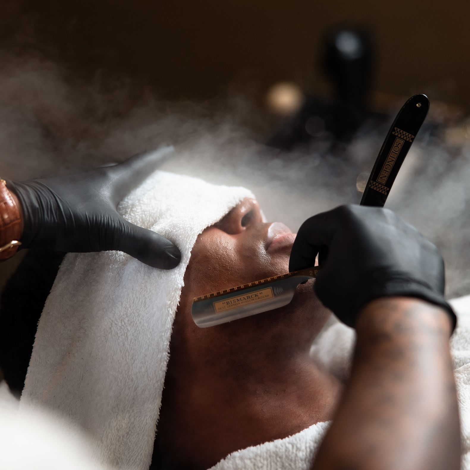 Groom receives a hot towel straight razor shave from JD Barba as part of a luxury wedding day grooming experience