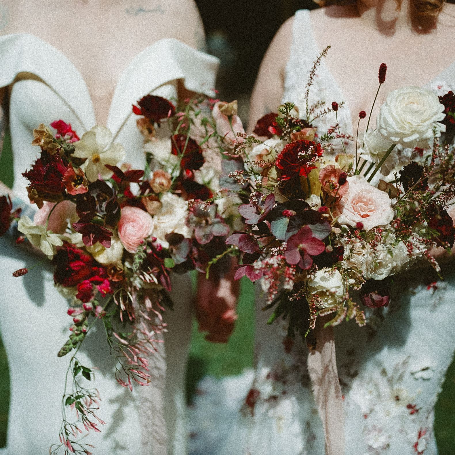 Two coordinating bridal bouquets in marsala wine colors for two brides