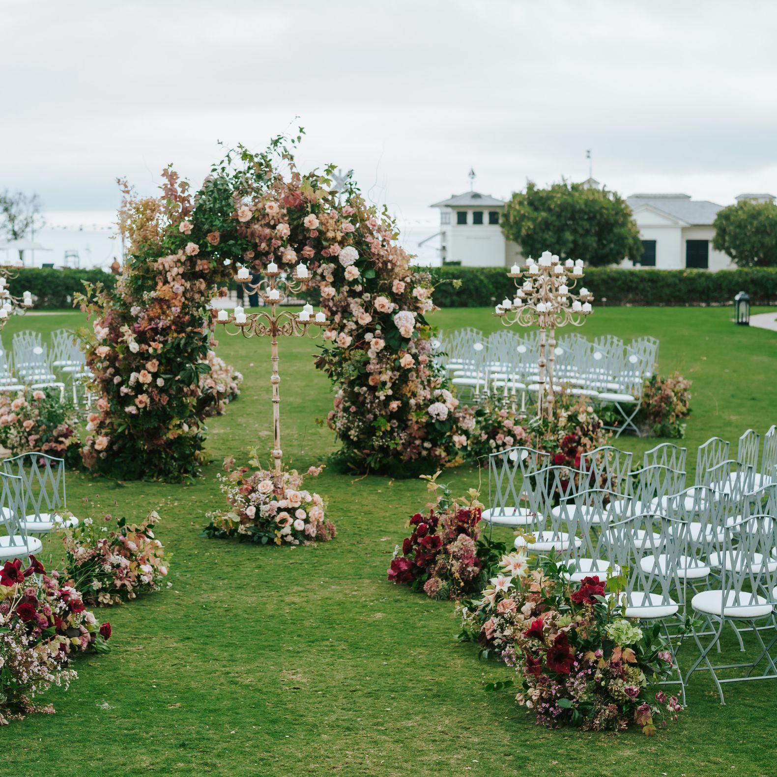 Outdoor wedding ceremony setup on The Great Lawn at Rosewood Miramar Beach with a circular floral arch and pastel-toned flowers