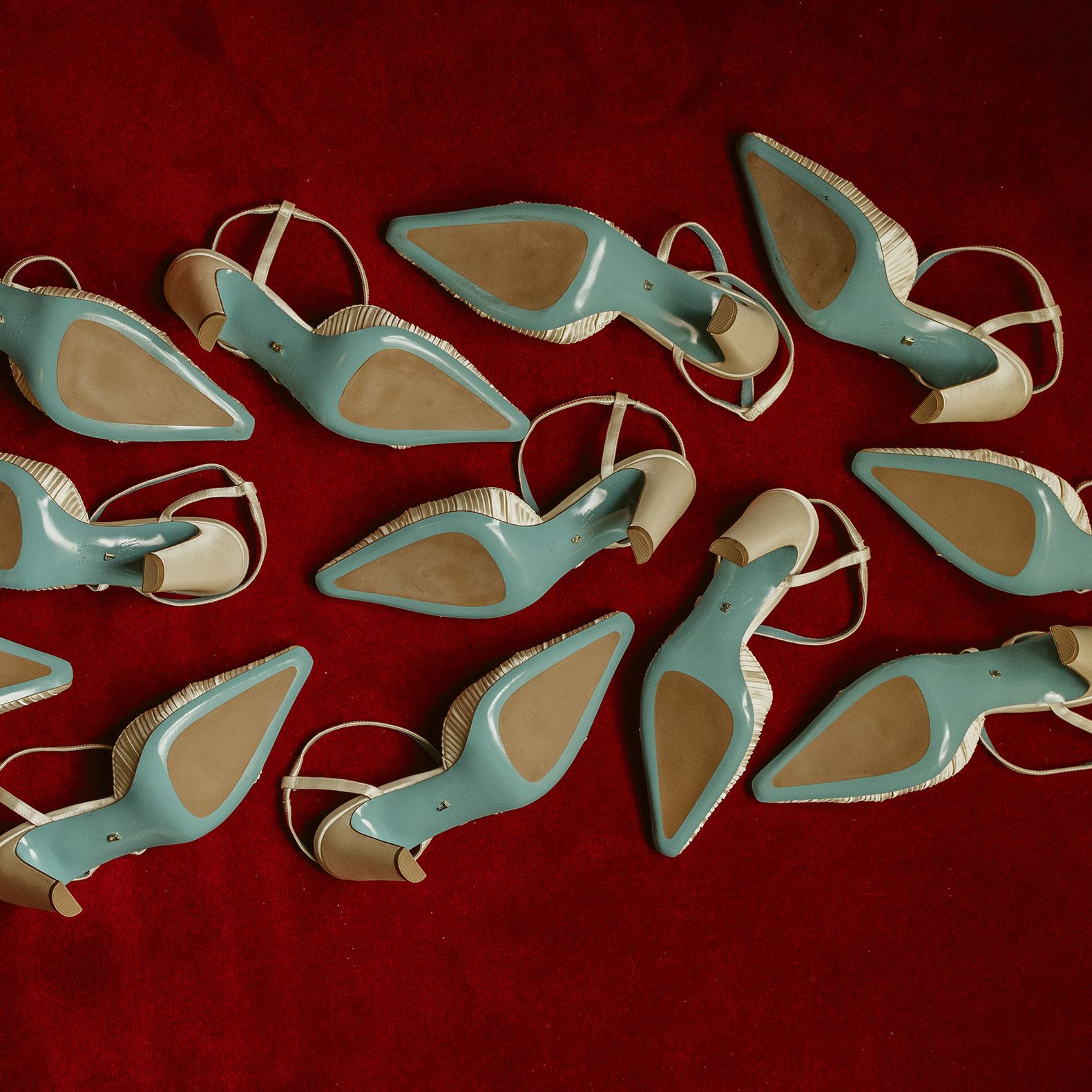 Six pairs of Valentina Rangoni designed shoes, soles up on a red carpet