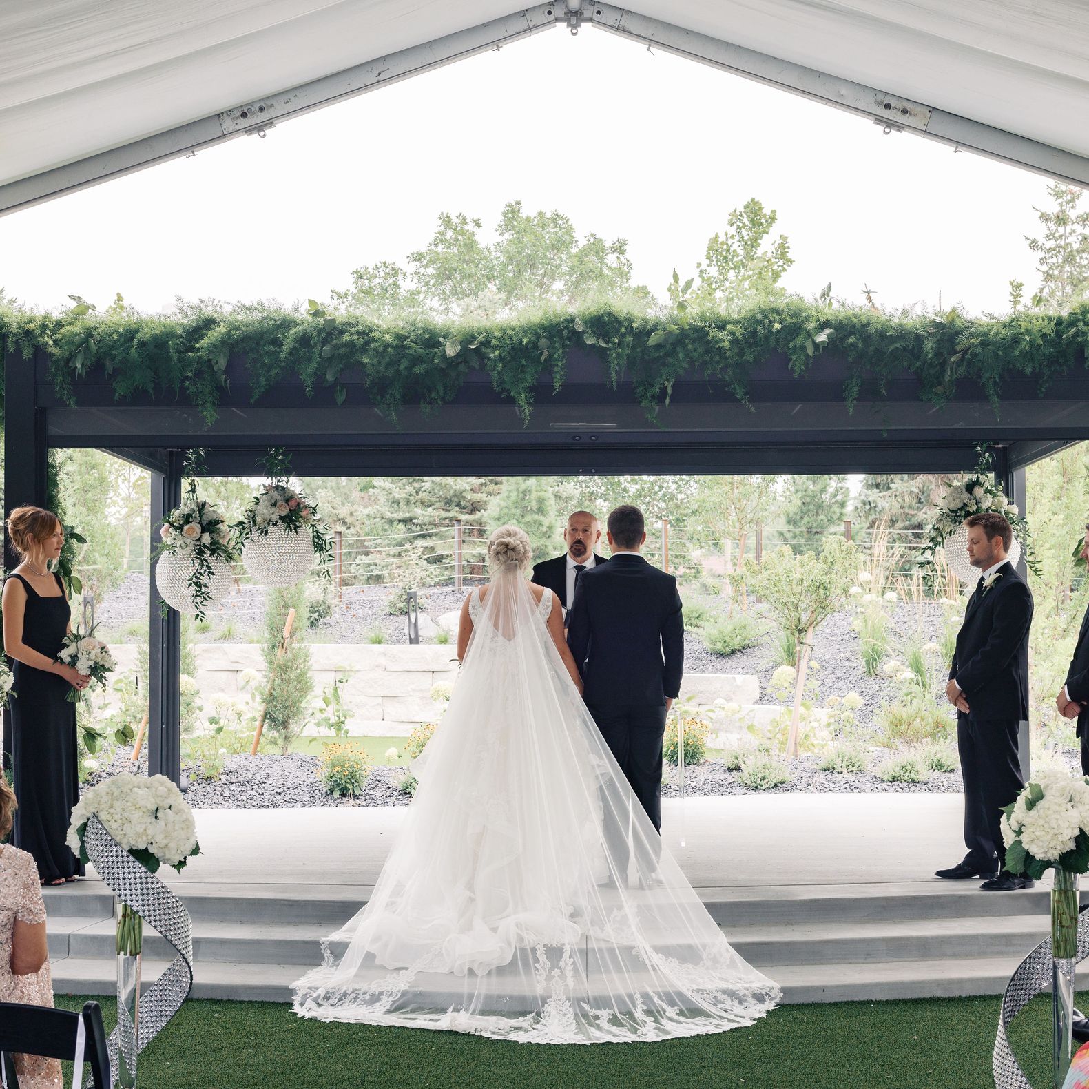 Bride and groom stand with backs facing the ceremony while standing at rectangular altar at Venue 5 Twenty-Two