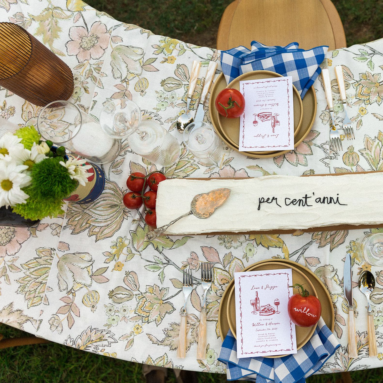 Horizontal cake with "per cent'anni" written in frosting on Italian-inspired tablescape featuring tomatoes as décor