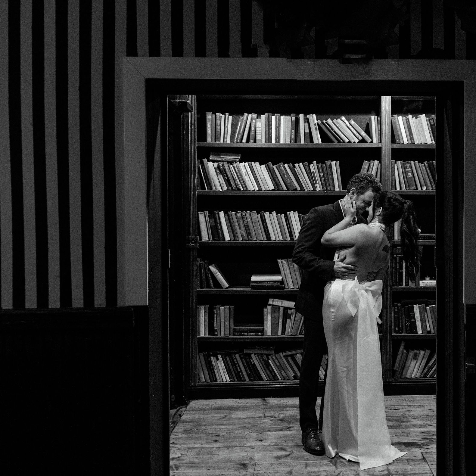 Bride and groom embrace in a library in fashionable wedding day at Ever After Ranch