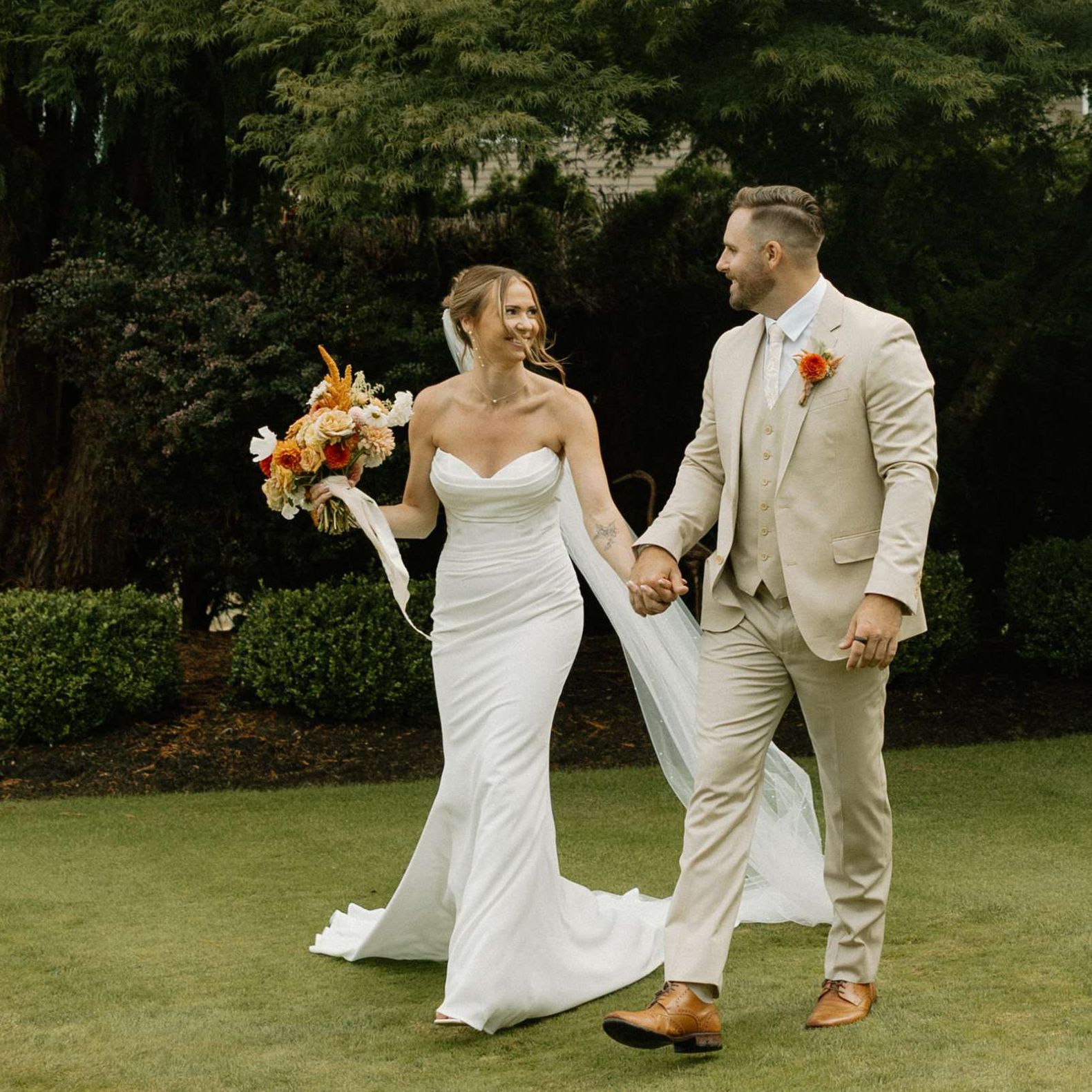 Sarah and Josh walk the grounds of the bride's childhood home on their lakeside wedding day