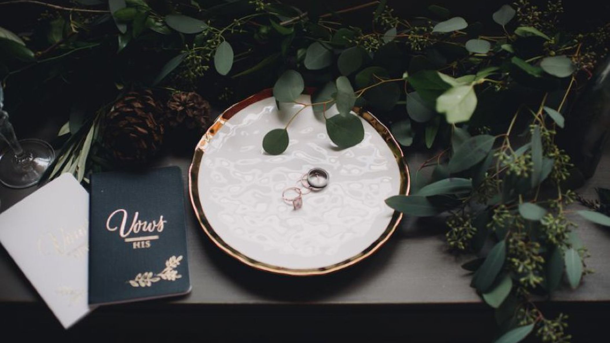 Wisconsin_Bride/StyledWinterShootMonicaCPhoto/866x578px.wedding_bands_on_marble_plate_with_vow_booklets_and_greenery_WEB.jpg