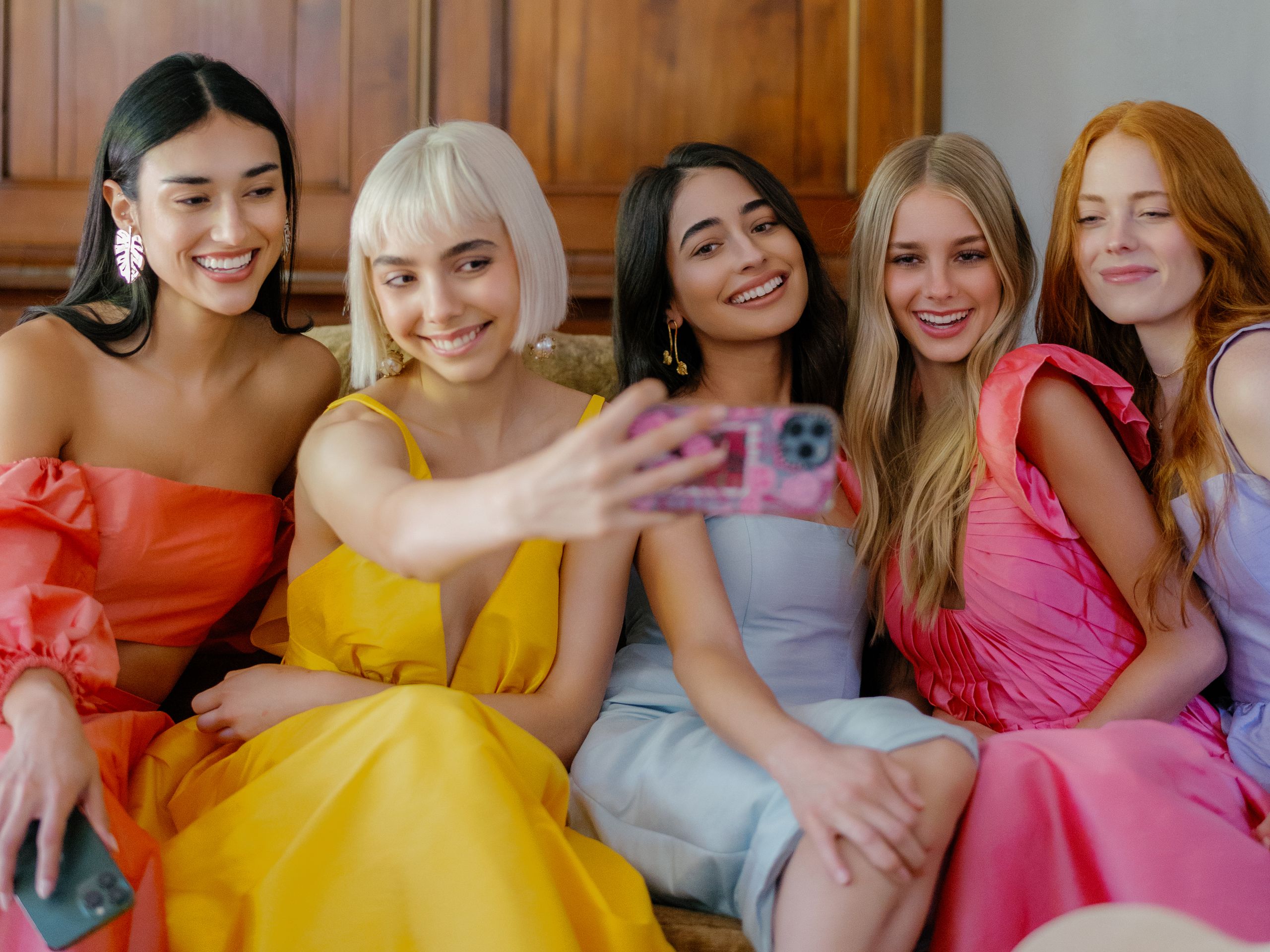 Models take a selfie in bright, summer-wedding-ready gowns by Watters