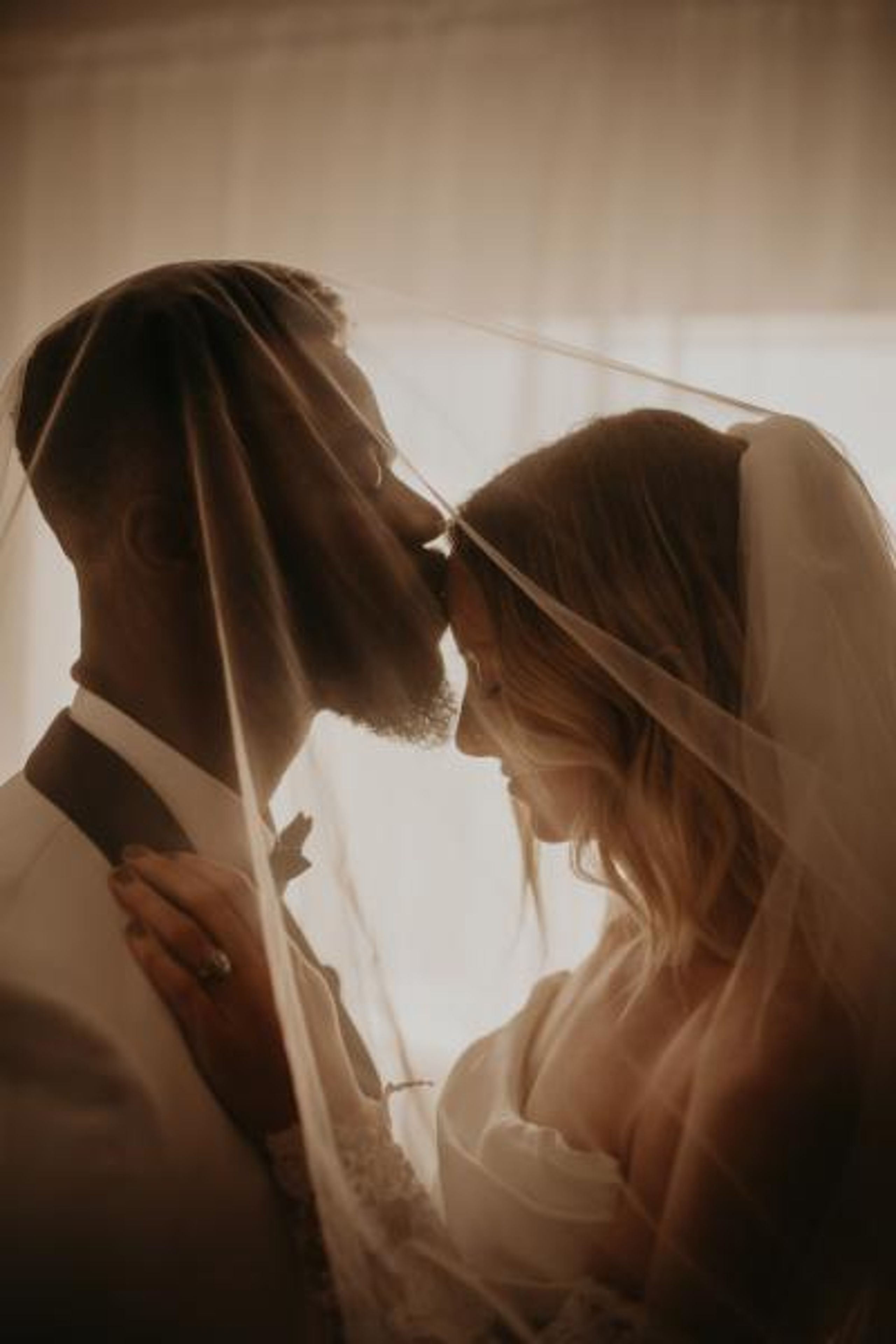 Groom kiss bride's forehead in close up shot in private wedding portrait session