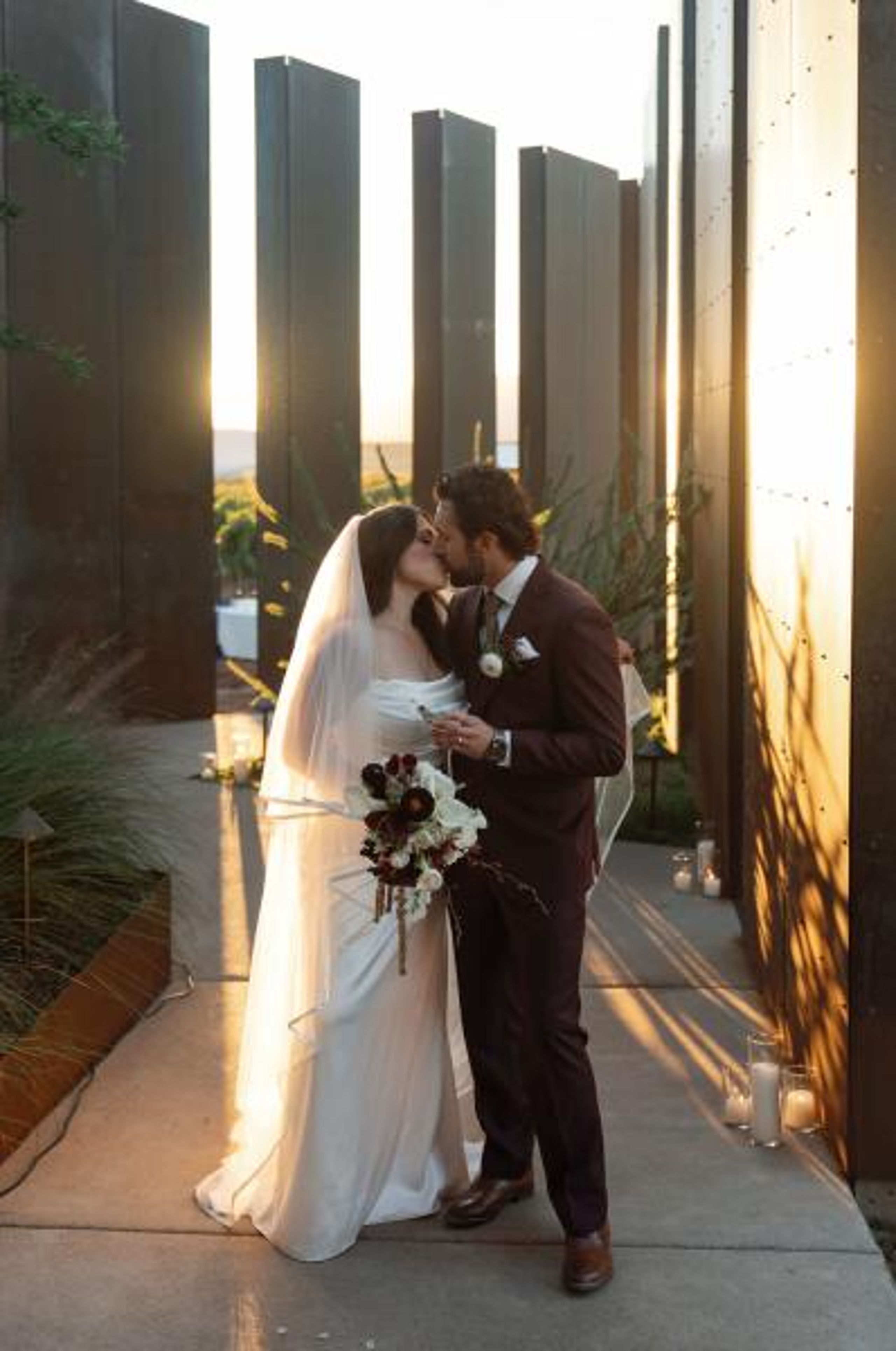 Jacquie and Ryan share a kiss amidst the modern structures at Los Milics Vineyards