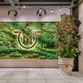 Verdant entryway with lush greenery and floral accents at the entrance of The Garden at The Penthouse in Beverly Hills.