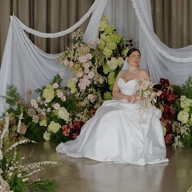 Model poses amidst florals and drapery in imagined ceremony at Abbey Road Farms