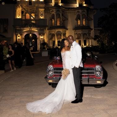 Marcelia and Renwick pose in front of vintage car outside of the Wisconsin Club