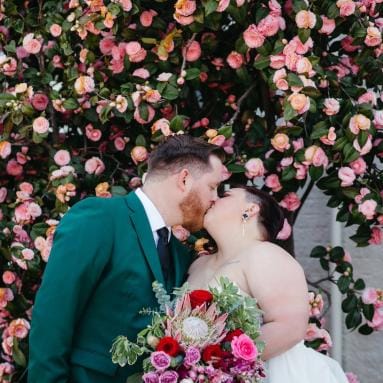 Molly and Kevin Share a Kiss in Modern and Vibrant Wedding with Unique Florals at Holbrooke Hotel