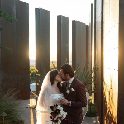 Jacquie and Ryan share a kiss amidst the modern structures at Los Milics Vineyards