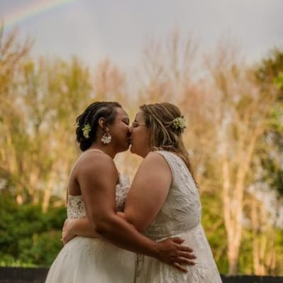 Couple shares a kiss under a rainbow