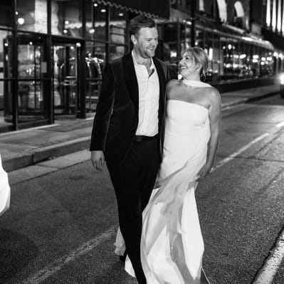 Couple walking out in the street outside of The Pfister Hotel, the location of their welcome party