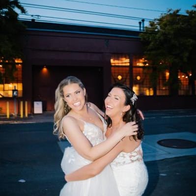 Brides share an embrace outside of their wedding day at The Ruins