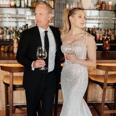 Kate and Tim pose with cocktails at the bar during their reception at Mara