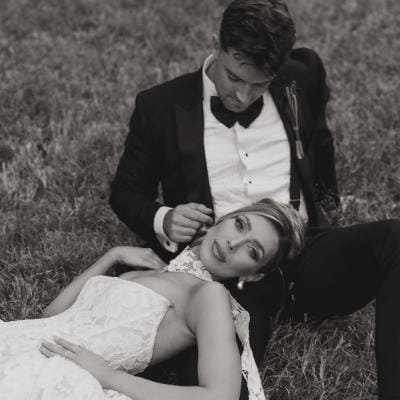 Bride rests her head on the groom's lap on their wedding day at Woods & Co.