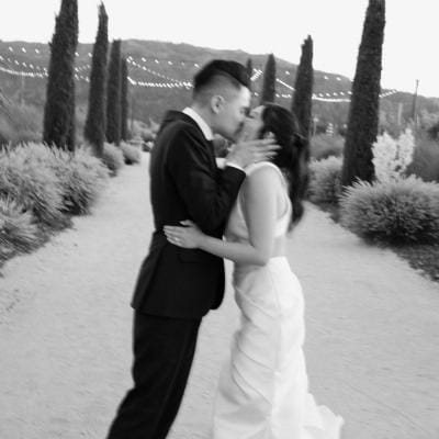 Stephanie and David Share a Kiss Outdoors at Wedding at Tre Posti
