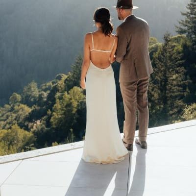 Bride and groom look out onto mountainous landscape 